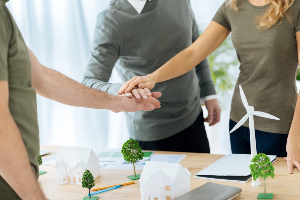 A first-time investor and her team shaking hands after making a successful  offer on her first investment property.