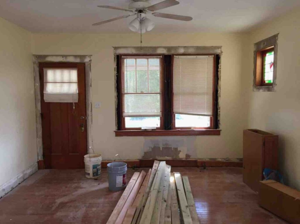 The before picture of the living room shows some lumber lying around.