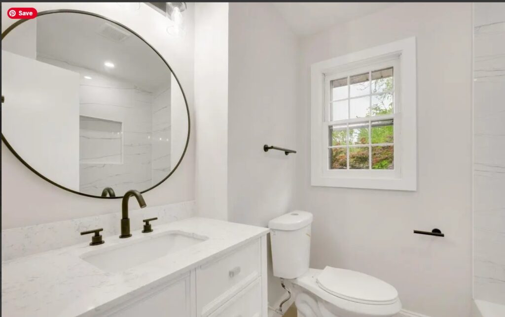 White bathroom with a round mirror