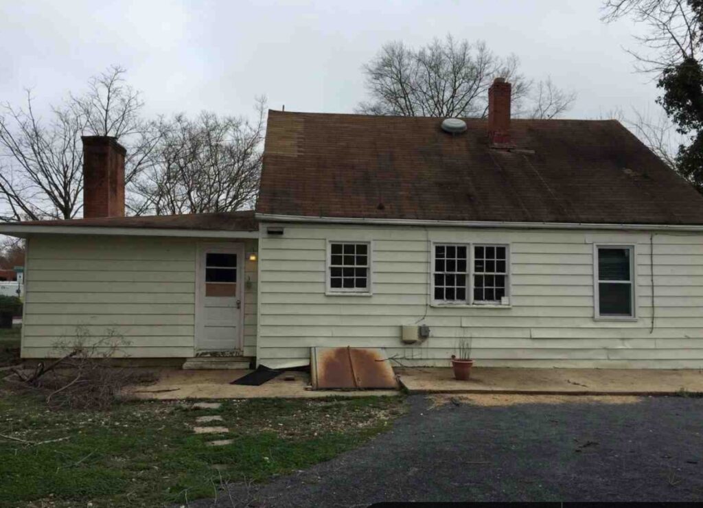 The before picture of the house with old roof and siding