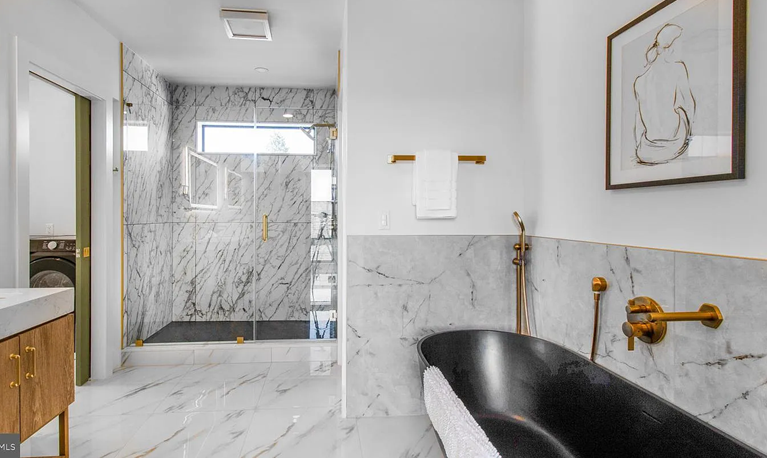 A view of the master bathroom with a black tub.
